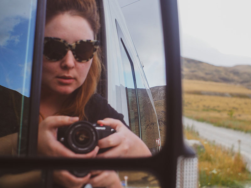 Woman driving campervan in New Zealand