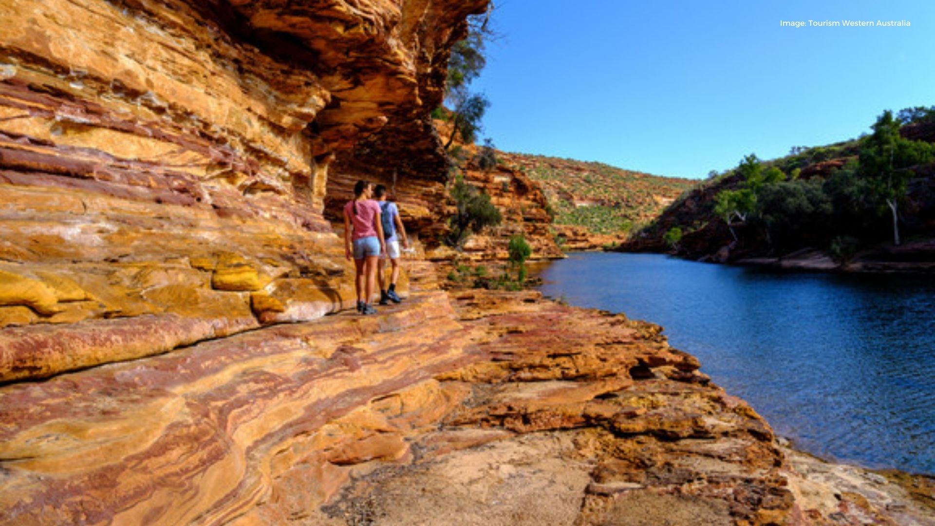 Couple walking on scenic rugged orange rock | Tourism Western Australia