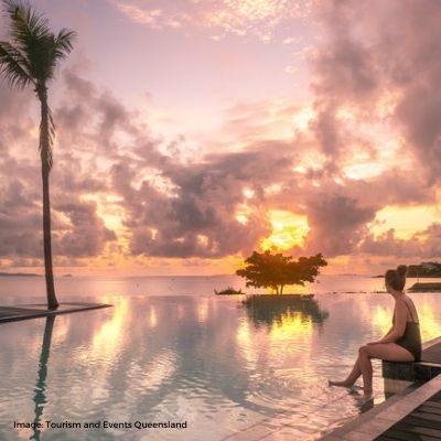 Tourism and Events Queensland -  girl sitting at infinity style pool at sunrise at Yeppoon Lagoon