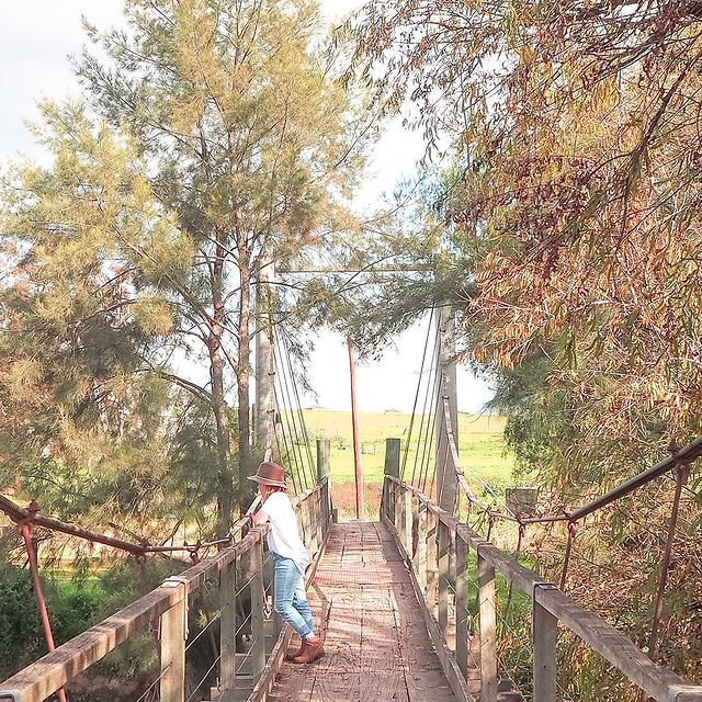Girl standing on bridge looking at forest view 